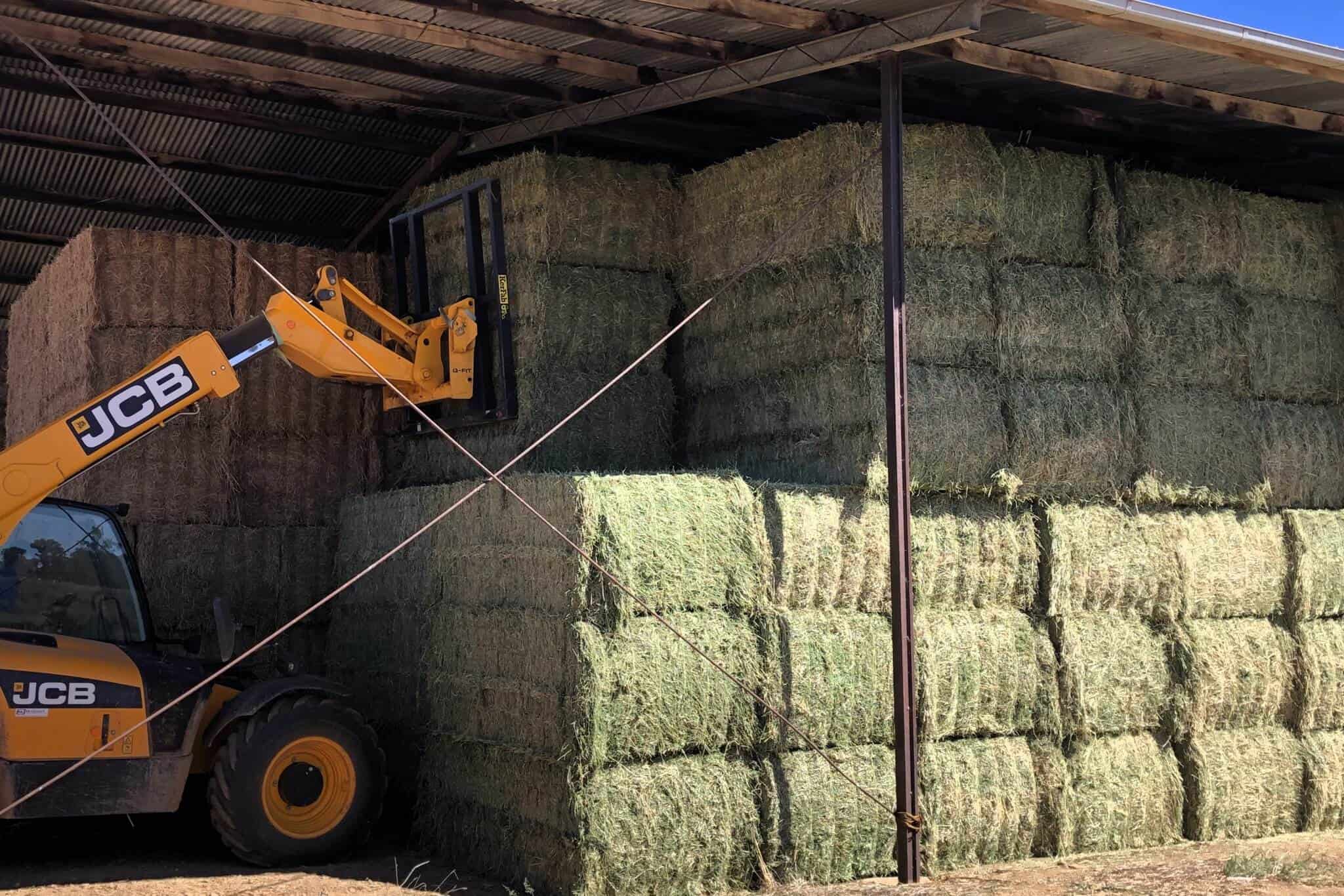 Bales of hay are stacked ready for sale and transport on the farm at Belubula Valley Hay
